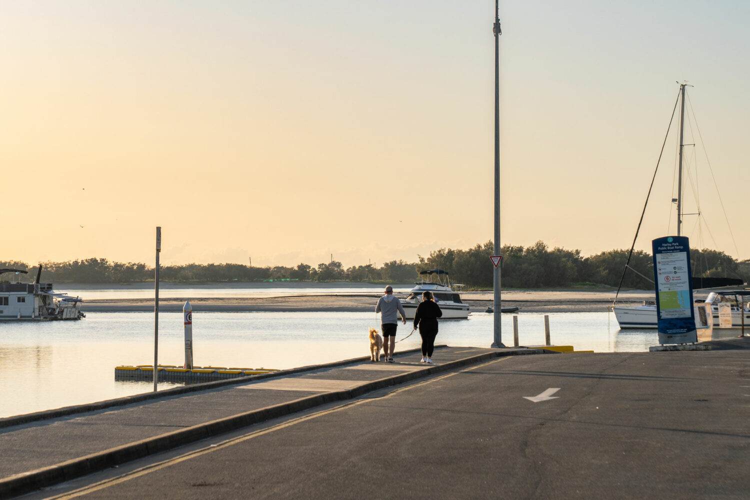 Two people by the Broadwater with a pet near the PARK SHORE development in Labrador on the Gold Coast