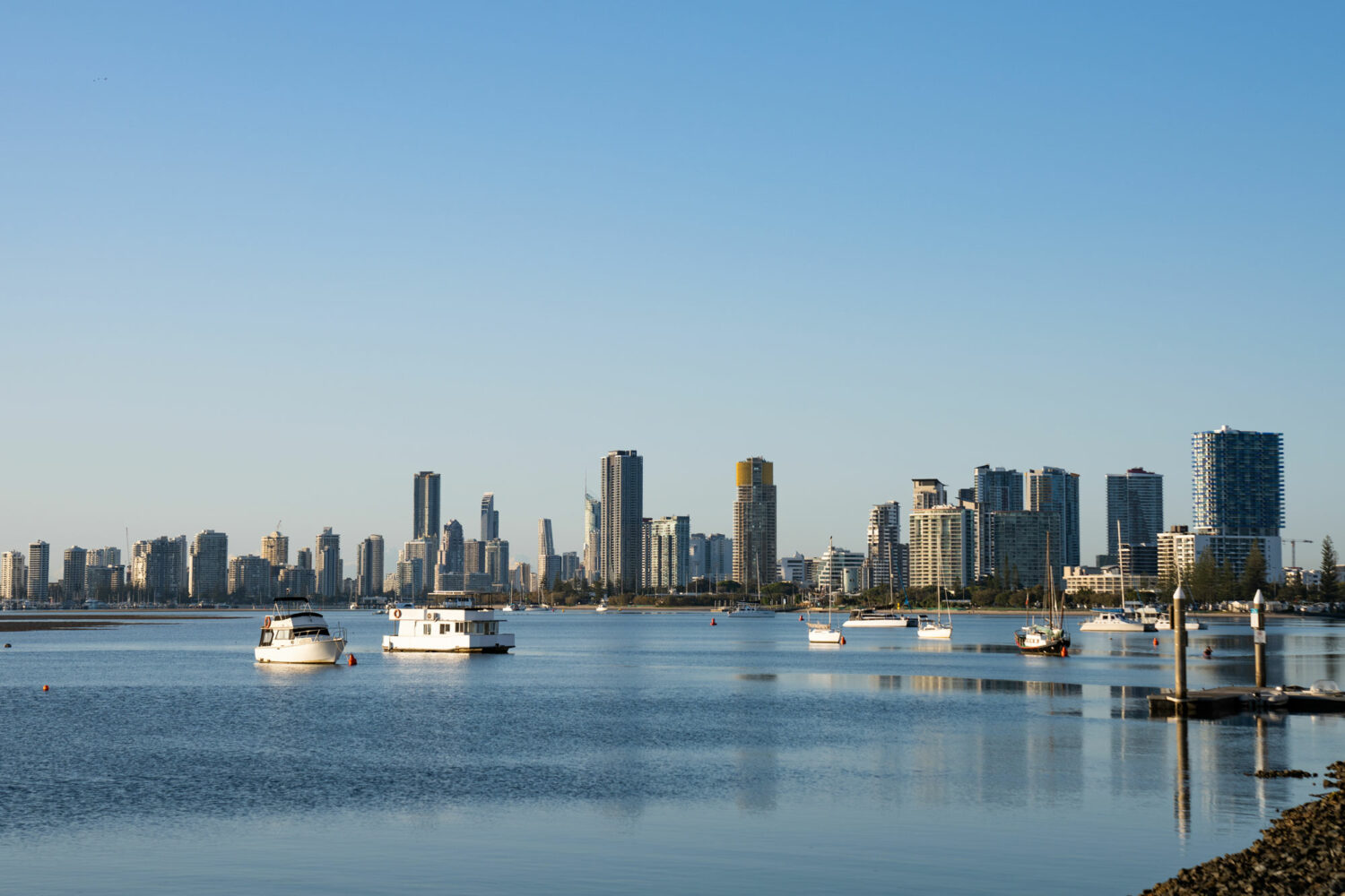 Looking towards the Gold Coast city skyline across the Broadwater from the Park Shore 2 & 3 bedroom apartments in Labrador. There are a number of boats in the foreground and highrise buildings in the background.